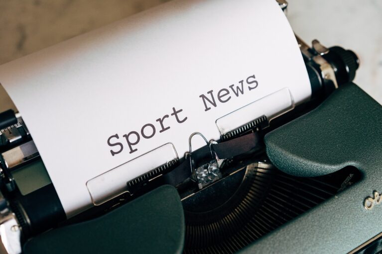 Une machine à écrire avec une feuille sur laquelle est écrit "Sport News".