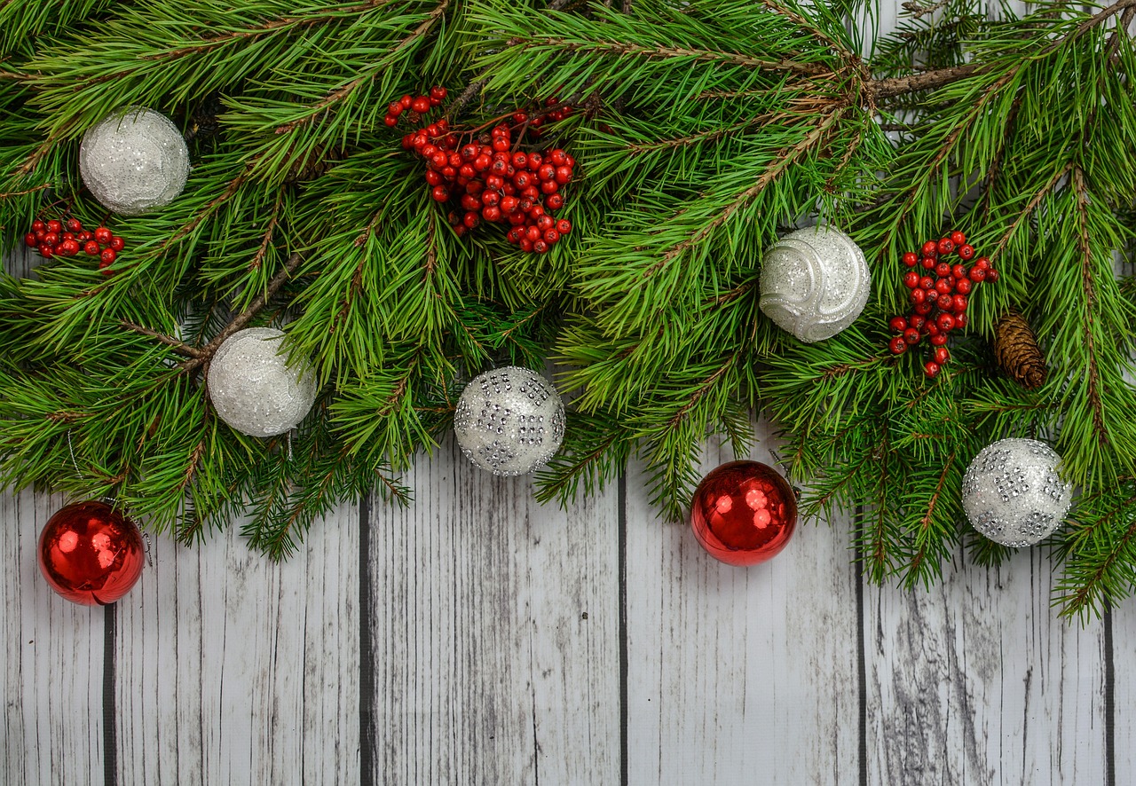 Des branches de sapins sur une table avec des décorations de Noël.